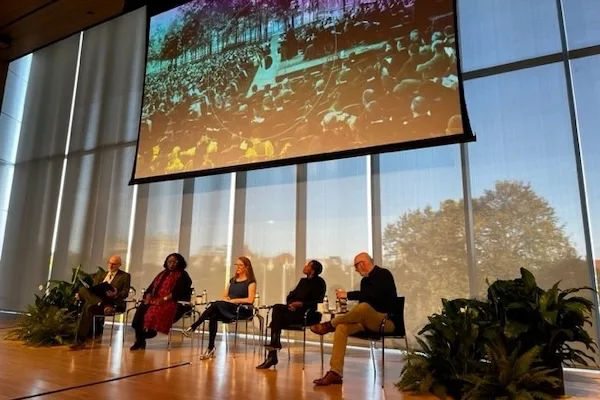 Photo of a group of women and men speaking on a conference panel
