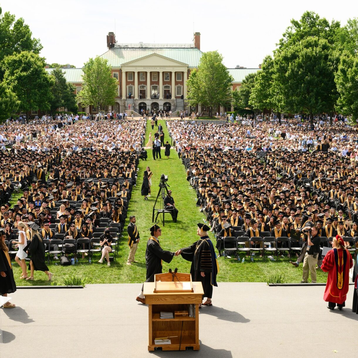 Susan Wente shaking hands with graduate at Wake Forest Commencement
